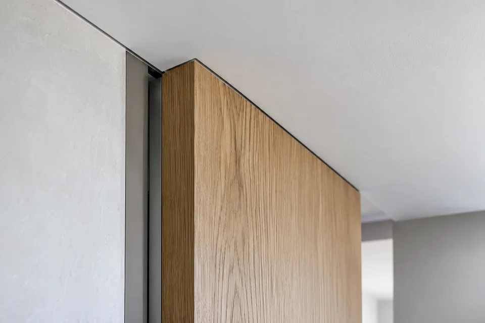 Top junction of a full-height interior door, wall and finished ceiling